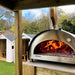 Igneus Pro 750 Wood-Fired Pizza Oven in garden with flames