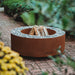 GrillSymbol Corten Steel Fire Pit Luna, ø 119 cm lifestyle image with logs