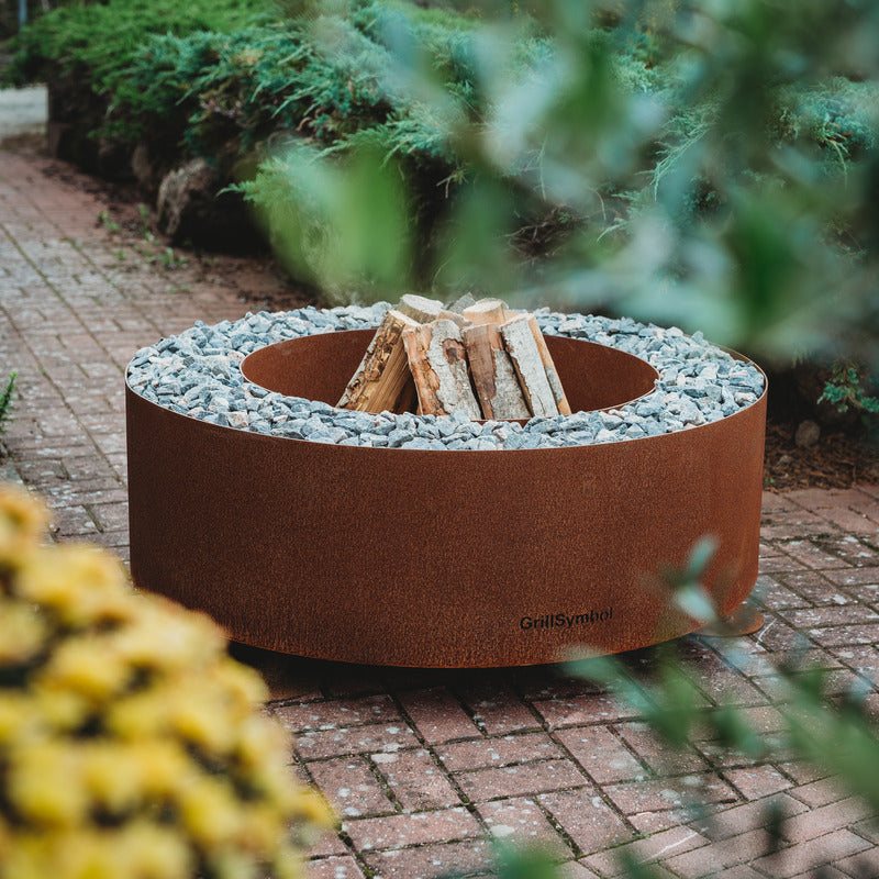 GrillSymbol Corten Steel Fire Pit Luna, ø 119 cm lifestyle image with logs