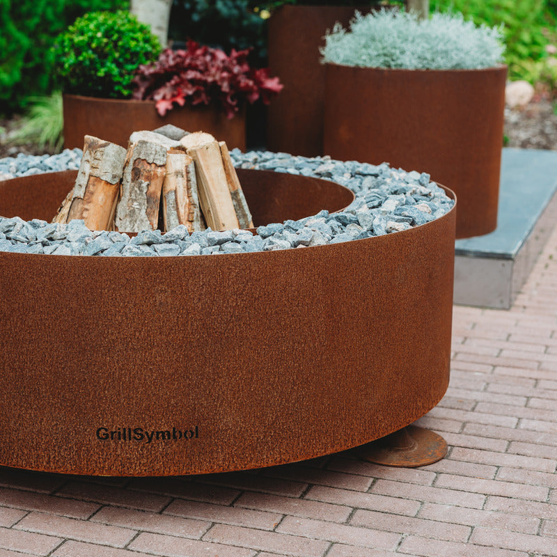 GrillSymbol Corten Steel Fire Pit Luna, ø 119 cm close up with logs