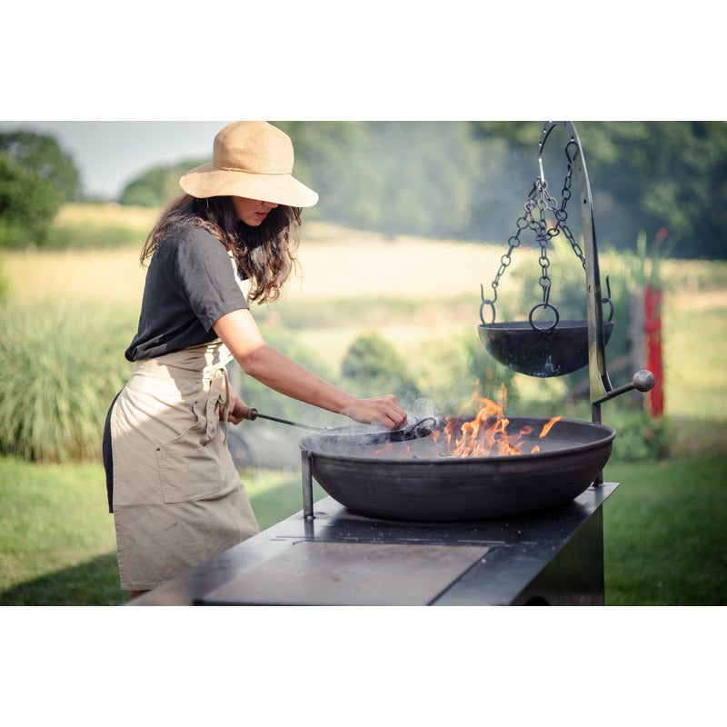 Complete Outdoor Kitchen Firepits UK cleaning long handed pan over complete outdoor kitchen with cooking bowl lit