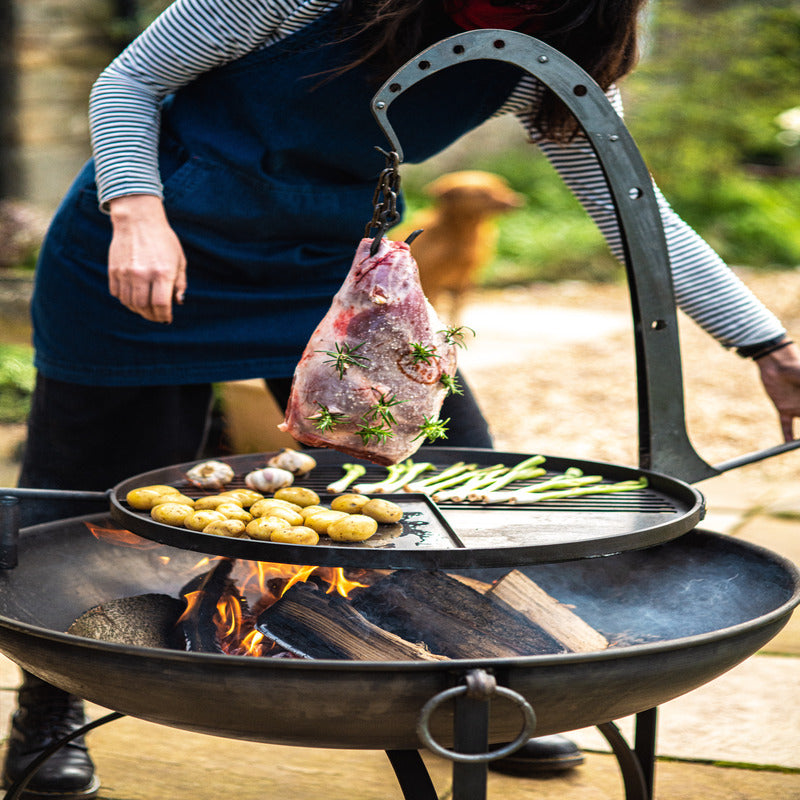 Firepits UK hanging arm with hook with leg of lamb over BBQ